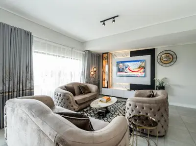a living room with two couches and a tv at 347 Waterfall Penthouse in Midrand
