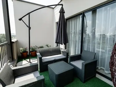 an apartment balcony with two chairs and an umbrella at 347 Waterfall Penthouse in Midrand