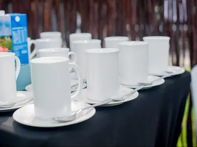 a black table with white cups and saucers on it at Silalise Lodge in Burgersfort