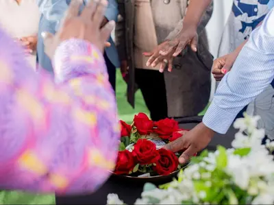 a group of people standing around a table with a bowl of roses at Silalise Lodge in Burgersfort