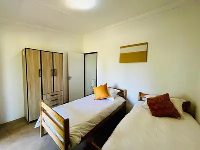 a bedroom with two beds and a cabinet at The Windmill Country Retreat in Hazyview