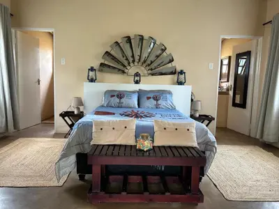 a bedroom with a large bed with a large mirror at The Windmill Country Retreat in Hazyview