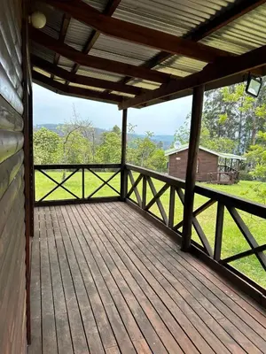 a large wooden deck with a view of a field at The Windmill Country Retreat in Hazyview