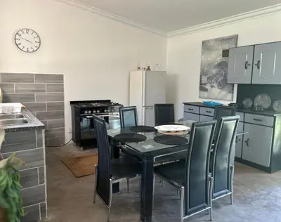 a kitchen with a black dining room table and chairs at The Windmill Country Retreat in Hazyview