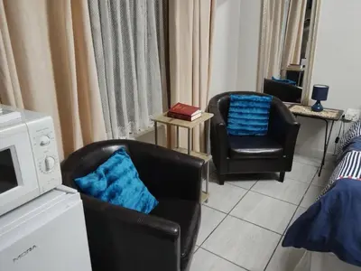 a living room with two chairs and a microwave at Kreuz in Evander