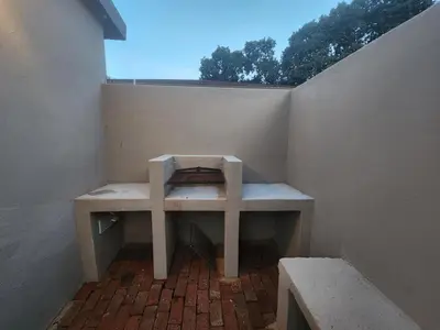 a bench sitting on a brick floor next to a wall at Ode to Serenity Cottage in Pretoria