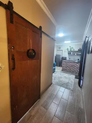 a large wooden door in a room with a hallway at Ode to Serenity Cottage in Pretoria