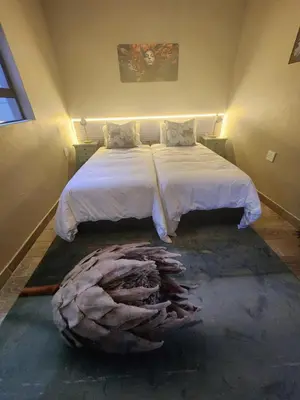 a bedroom with a large bed with a large bed sqor at Ode to Serenity Cottage in Pretoria
