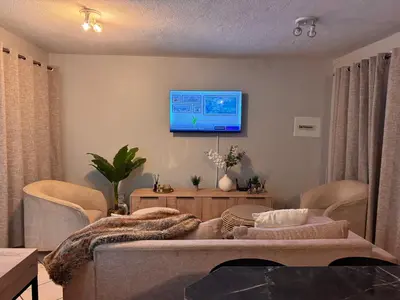 a living room with a couch and a tv on the wall at Centurion La Creme Apartment II in Centurion
