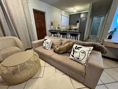 a living room with a couch with pillows on it at Centurion La Creme Apartment II in Centurion