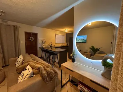 a living room with a couch and a large mirror at Centurion La Creme Apartment II in Centurion