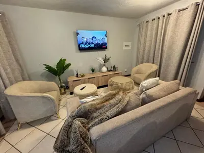 a living room with a couch and chairs and a tv at Centurion La Creme Apartment II in Centurion