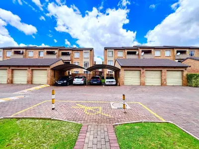 a parking lot in front of a building with cars at Centurion La Creme Apartment II in Centurion