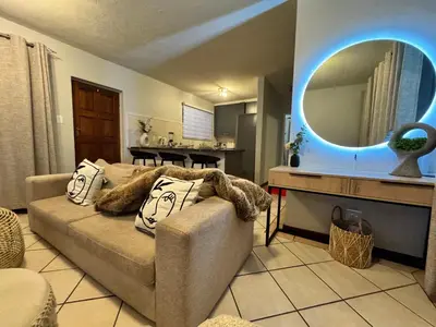 a living room with a couch and a mirror at Centurion La Creme Apartment II in Centurion