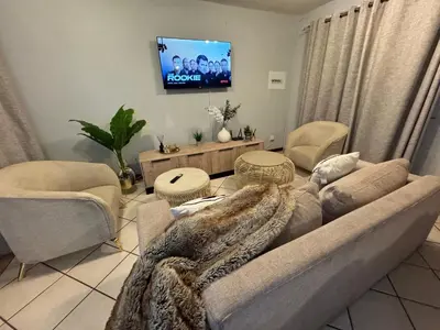 a living room with a couch and a tv at Centurion La Creme Apartment II in Centurion