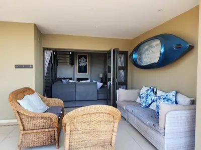 a living room with a couch and two chairs at BondMakers Blue Canoe in Hartbeespoort
