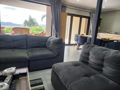 a living room with a couch and a table at BondMakers Blue Canoe in Hartbeespoort
