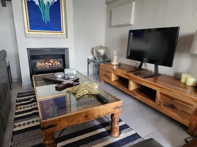 a living room with a television and a fireplace at BondMakers Blue Canoe in Hartbeespoort