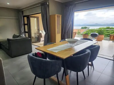 a dining room with a wooden table and chairs at BondMakers Blue Canoe in Hartbeespoort