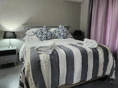 a bed with a black and white striped blanket at BondMakers Blue Canoe in Hartbeespoort