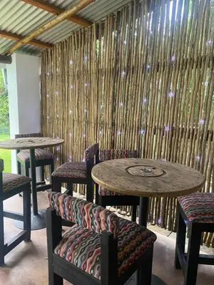 a table and chairs in a room with a bamboo wall at Georges Valley Lodge in Tzaneen