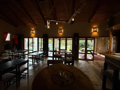 a dining room with tables and chairs and windows at Georges Valley Lodge in Tzaneen