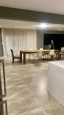 a large room with a table and chairs and a woman at 114 Zinnia Road in Midrand