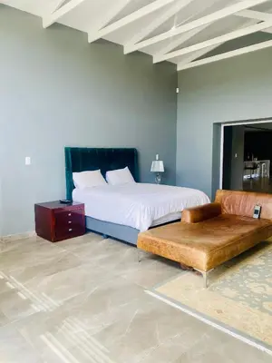 a bedroom with a bed and a couch in a room at 114 Zinnia Road in Midrand