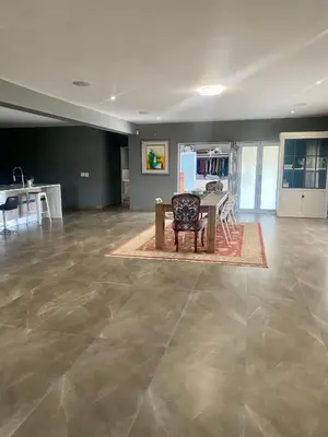 an empty living room with a table and a chair at 114 Zinnia Road in Midrand