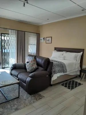 a living room with a couch and a bed at Bustani 1 Self Catering Studio Minimum 2 Nights in Edenvale