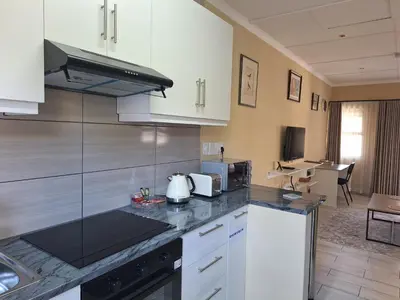 a kitchen with white cabinets and a counter top at Bustani 1 Self Catering Studio Minimum 2 Nights in Edenvale