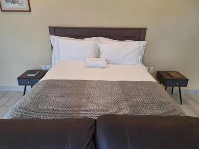 a bedroom with a large bed with two night stands at Bustani 1 Self Catering Studio Minimum 2 Nights in Edenvale