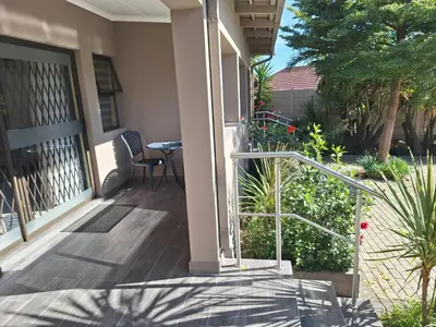 a porch of a house with a table and chairs at Bustani 1 Self Catering Studio Minimum 2 Nights in Edenvale