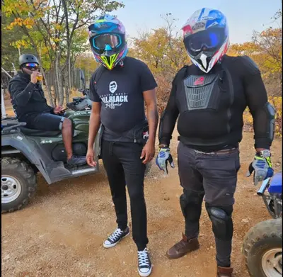two people standing next to a man in a motorcycle at Sunset Game Farm in Mopane