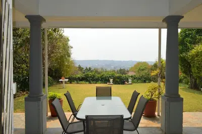 a table and chairs on a patio with a view of a field at 512 Berea in Pretoria