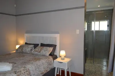 a bedroom with a bed and a glass shower at 512 Berea in Pretoria