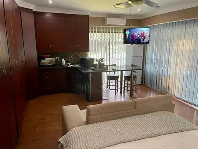 a living room with a couch and a kitchen with a table at Spies Villa - Fast Wi-fi, Netflix, DSTV, Solar, Certified Water System in Middelburg