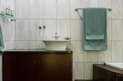 a bathroom with a sink and a green towel at Spies Villa - Fast Wi-fi, Netflix, DSTV, Solar, Certified Water System in Middelburg
