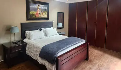 a bedroom with a bed and two lamps and a painting at Spies Villa - Fast Wi-fi, Netflix, DSTV, Solar, Certified Water System in Middelburg