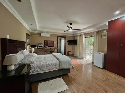 a large bedroom with a bed and a television at Spies Villa - Fast Wi-fi, Netflix, DSTV, Solar, Certified Water System in Middelburg