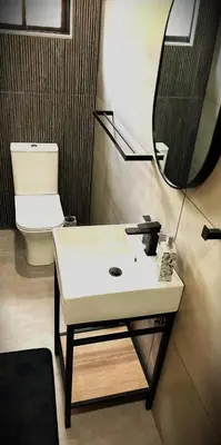 a bathroom with a sink and a mirror and a toilet at Spasie 30 Harties in Hartbeespoort
