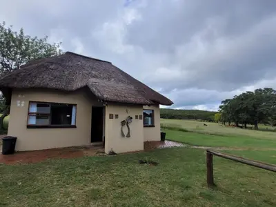 a small hut with a thatched roof on a field at Lush Horizons Game Lodge in Modimolle
