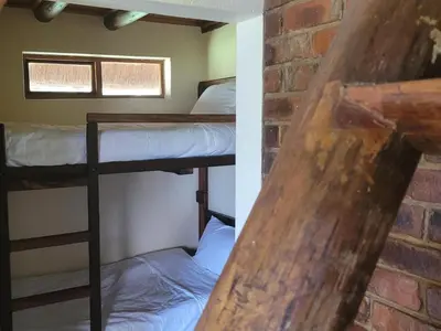 two bunk beds in a room with a brick wall at Lush Horizons Game Lodge in Modimolle