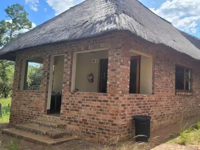 a brick building with a grass roof at Lush Horizons Game Lodge in Modimolle