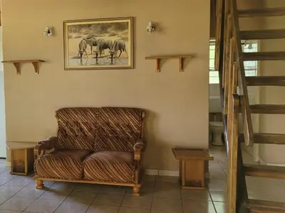 a chair in a room with a picture of elephants at Lush Horizons Game Lodge in Modimolle