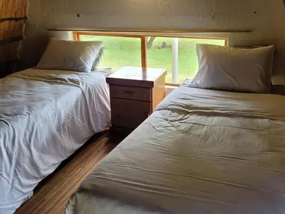 two beds in a small room with a window at Lush Horizons Game Lodge in Modimolle