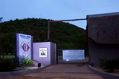 a gate to a building with a mountain in the background at Thaba Pitsi Safari Lodge in Bela-Bela