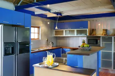 a kitchen with blue cabinets and a counter with drinks on it at Thaba Pitsi Safari Lodge in Bela-Bela