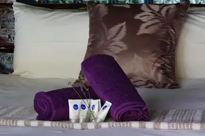 a pair of purple towels and toothbrushes on a bed at Thaba Pitsi Safari Lodge in Bela-Bela