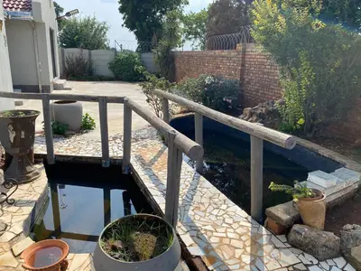 a patio with a wooden railing and a pool of water at Crystal Park Guest house in Benoni